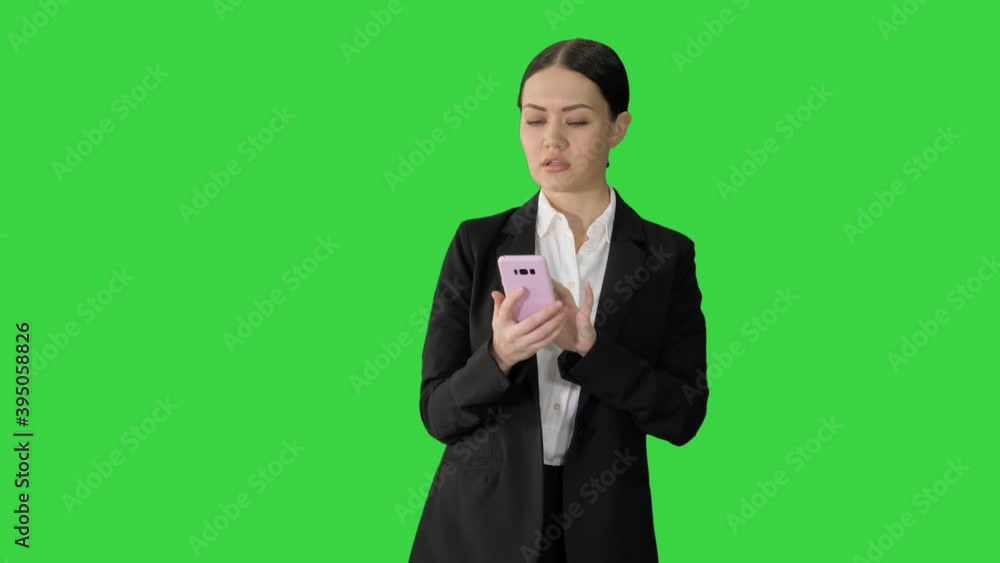 Disapprovingly looking business woman using her phone on a Green Screen, Chroma Key. Disapprovingly looking business woman using her phone on a Green Screen, Chroma Key.