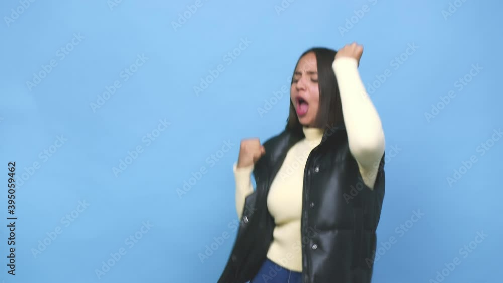 Young mixed race woman raising fist after a victory, winner concept Young mixed race woman raising fist after a victory, winner concept