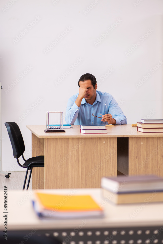 Young male teacher in the classroom Young male teacher in the classroom