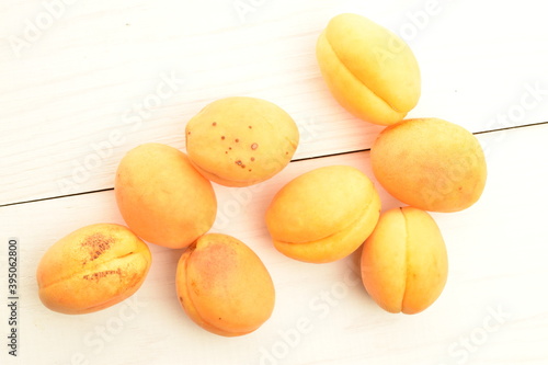 Several ripe yellow pineapple apricots, close-up, on a wooden table.