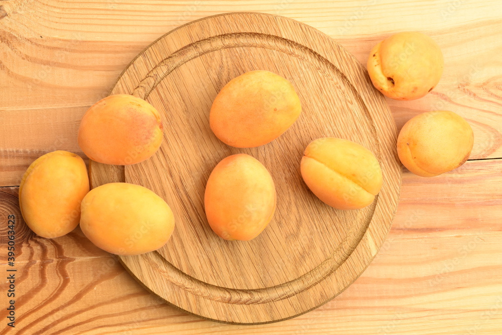Several ripe yellow pineapple apricots, close-up, on a wooden table.