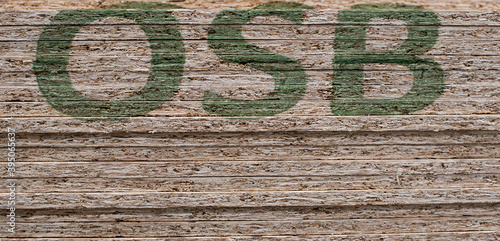 OSB sheets are stacked in a hardware store. The building material is wood.