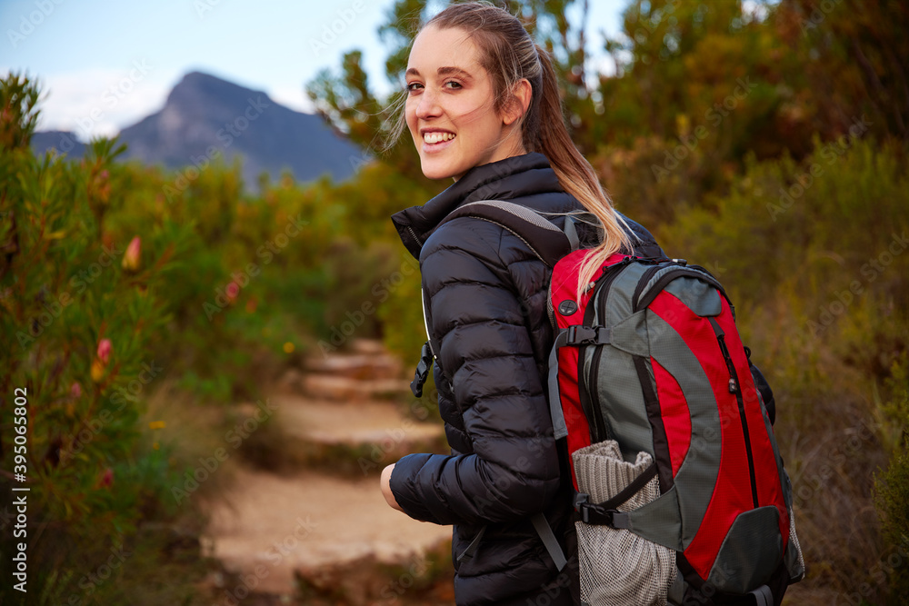 Portrait Of Young Woman With Backpack Hiking Along Path Through Countryside Portrait Of Young Woman With Backpack Hiking Along Path Through Countryside