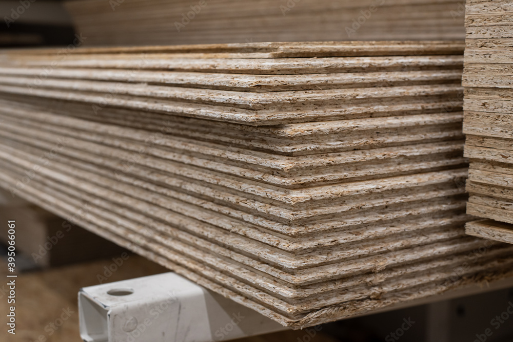 OSB sheets are stacked in a hardware store. The building material is wood. OSB sheets are stacked in a hardware store. The building material is wood.