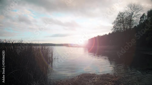 Sunset over the lake. Beautiful landscape. Sun, water, forest, beach.