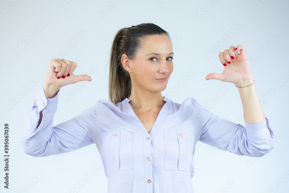 Portrait of caucasian woman in casual shirt with thumbs herself. She is proud of herself. Portrait of caucasian woman in casual shirt with thumbs herself. She is proud of herself.