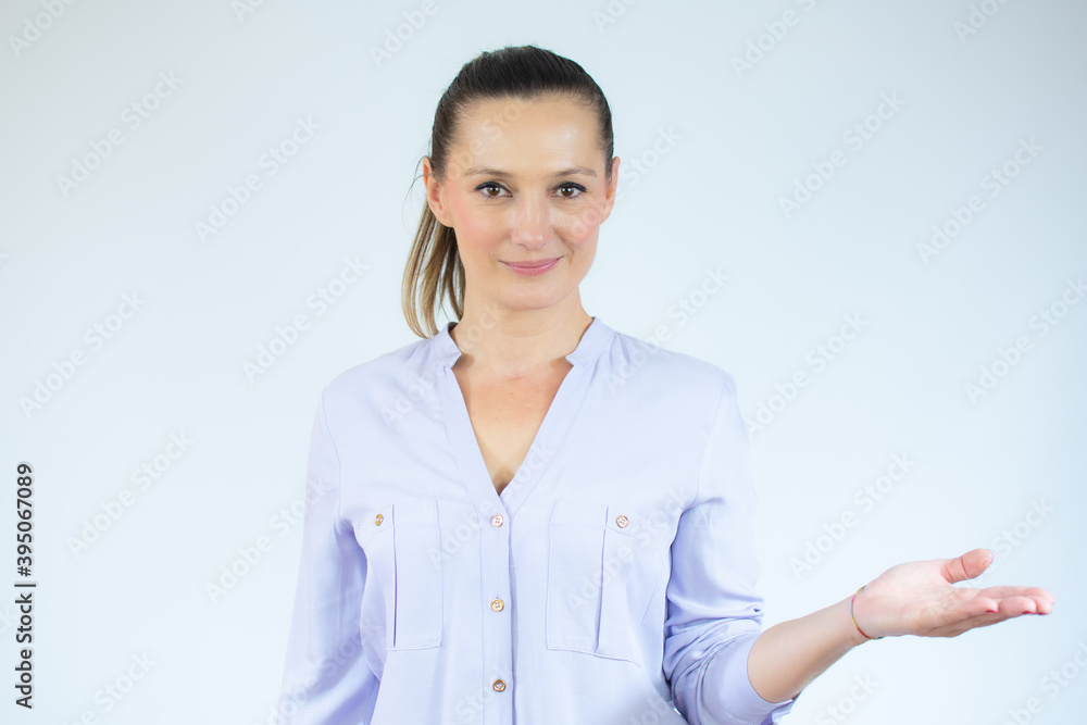 Beautiful young woman standing isolated over white background. Looking camera showing copy space pointing. Copy space for your text or advertising content. Beautiful young woman standing isolated over white background. Looking camera showing copy space pointing. Copy space for your text or advertising content.