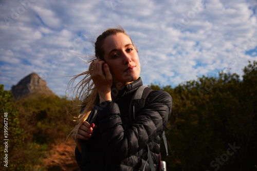 Portrait Of Young Woman With Backpack Hiking Along Path Through Countryside