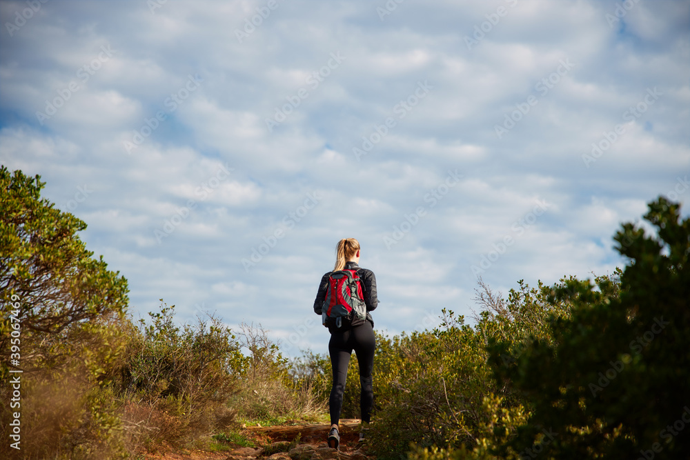 Rear View Of Young Woman With Backpack Setting Off For Hike Along Path Through Countryside Rear View Of Young Woman With Backpack Setting Off For Hike Along Path Through Countryside