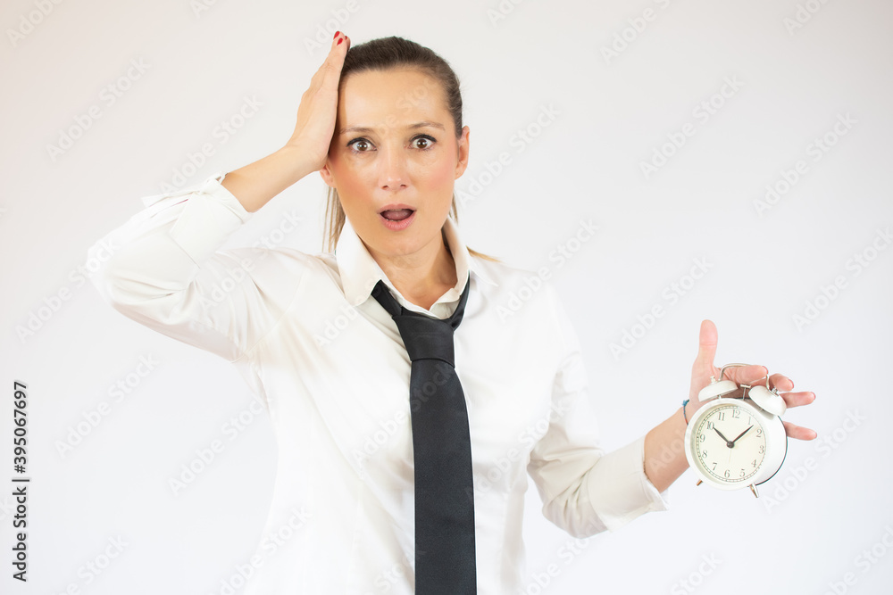 Business caucasian woman holding alarm clock on a white background Business caucasian woman holding alarm clock on a white background