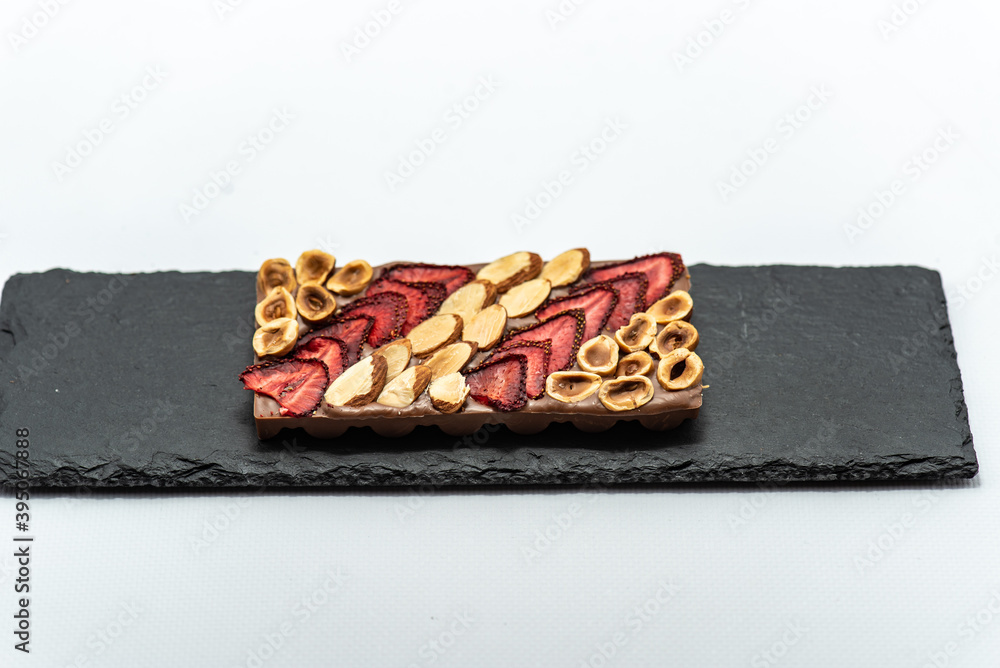 Chocolate bar with the addition of fruit nuts on background. Dessert food concept. Chocolate bar with the addition of fruit nuts on background. Dessert food concept.