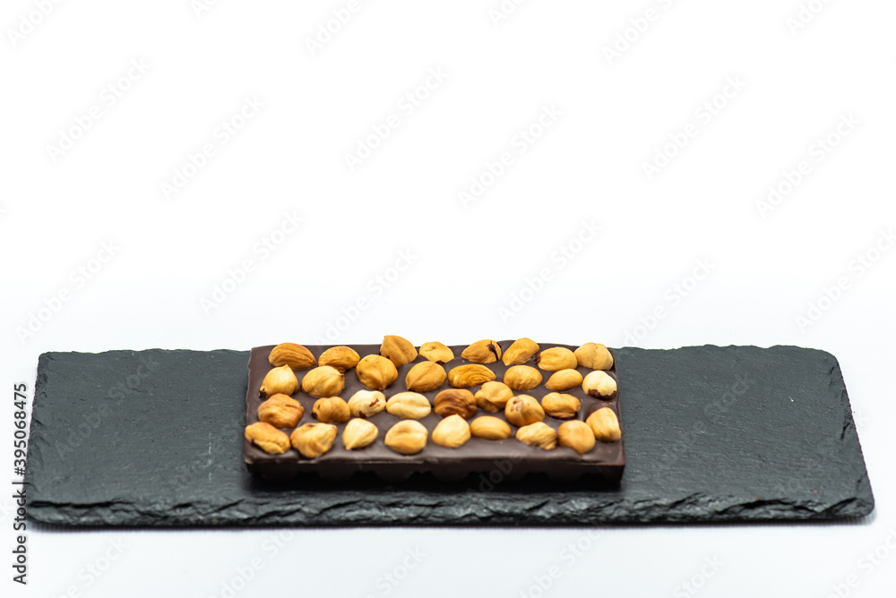 Chocolate bar with the addition of fruit nuts on background. Dessert food concept. Chocolate bar with the addition of fruit nuts on background. Dessert food concept.