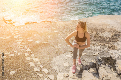 Woman running training on the coastline under sunlight in sunny