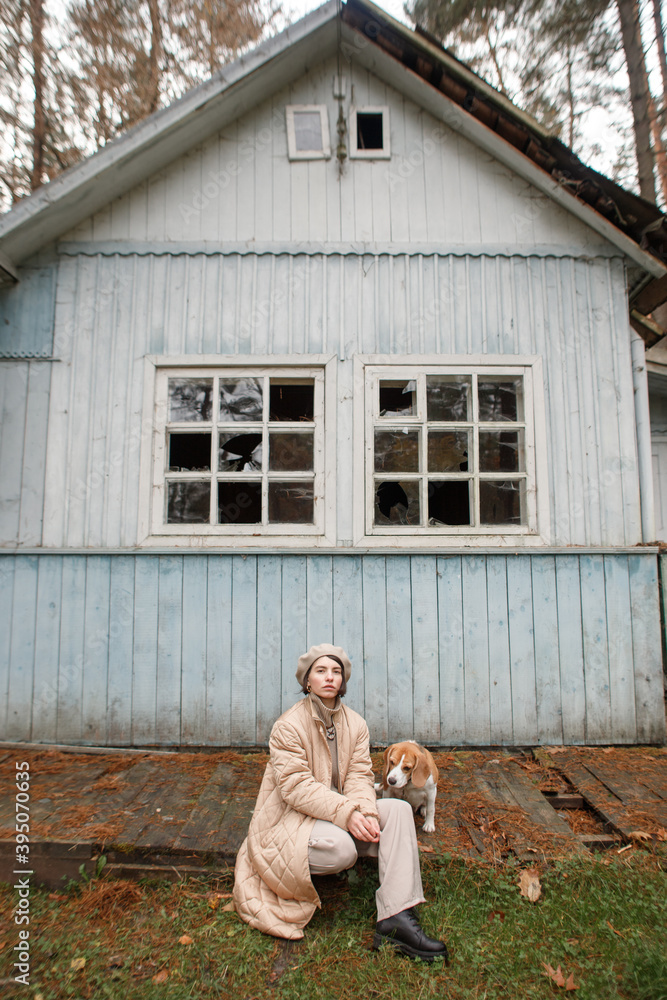 young woman with a beagle dog in the autumn forest near the old house young woman with a beagle dog in the autumn forest near the old house
