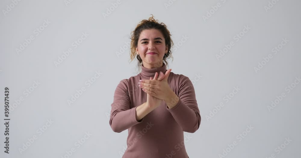 Excited woman clapping hands and cheering over white background