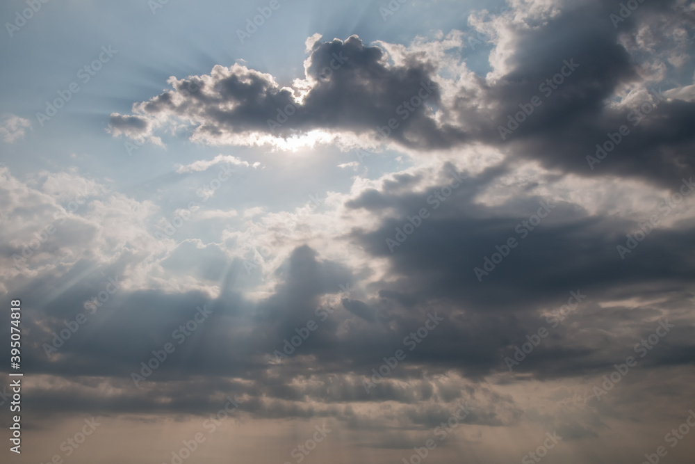 Dramatic clouds and sun behind on sky background Dramatic clouds and sun behind on sky background