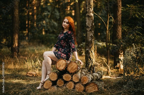 Rudowłosa kobieta w lesie w sukience