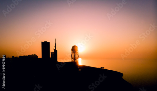 Panoramic silhouette of Batumi city skyscrapers from distance with blue sea water in the background. Georgiatravel iliustration concept.