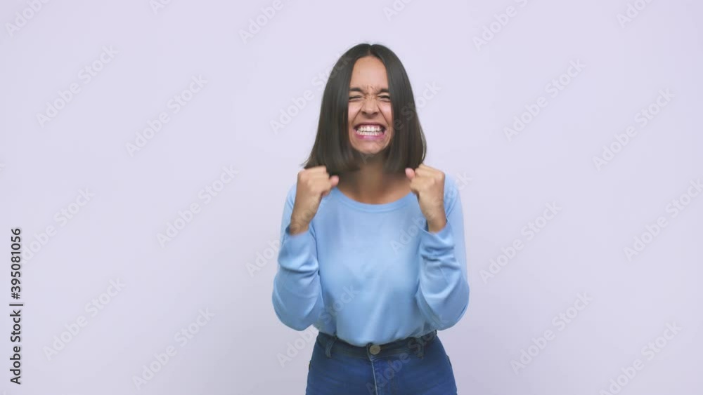 Young mixed race woman raising fist after a victory, winner concept Young mixed race woman raising fist after a victory, winner concept