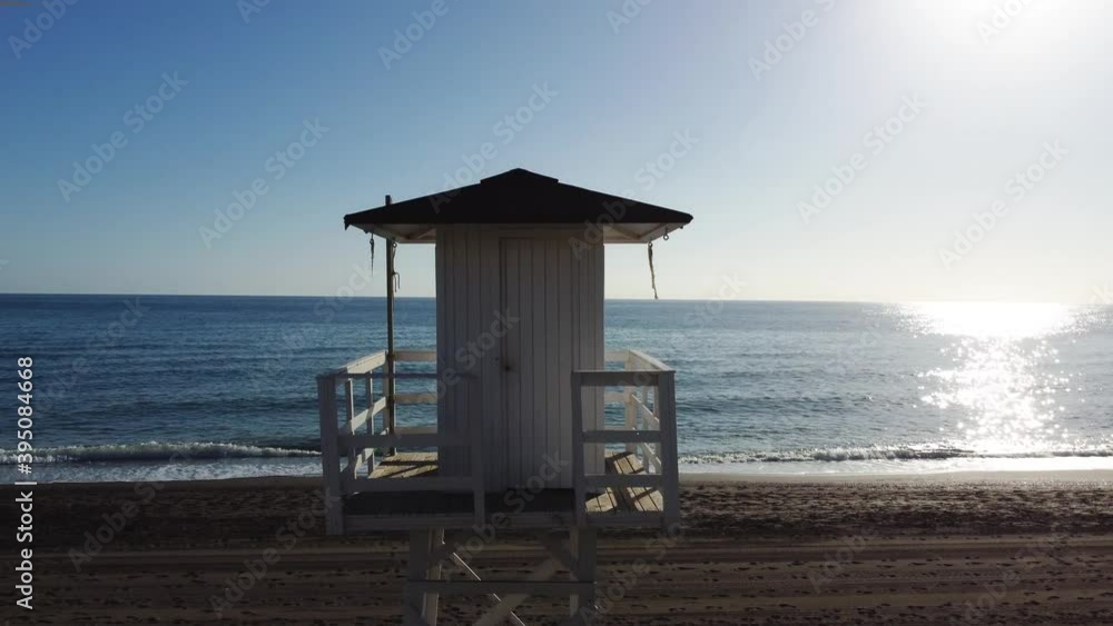 Mediterranean beach. A relaxing outdoors view of the shore with vintage and lonely lifeguard wooden tower in the sunset hour. Mediterranean beach. A relaxing outdoors view of the shore with vintage and lonely lifeguard wooden tower in the sunset hour.