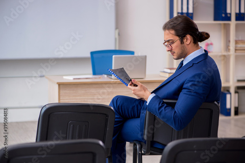 Young male business trainer in the office during pandemic