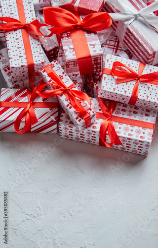 A pile various size wrapped in festive paper boxed gifts placed on stack. Christmas concept