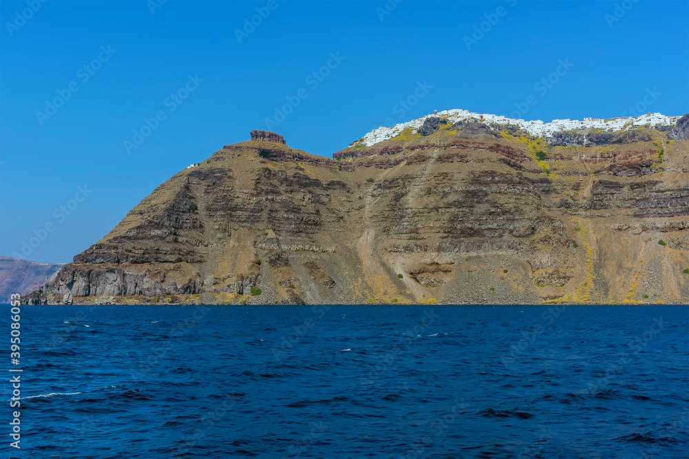 A panorama view from a boat towards Skaros Rock, Santorini in summertime