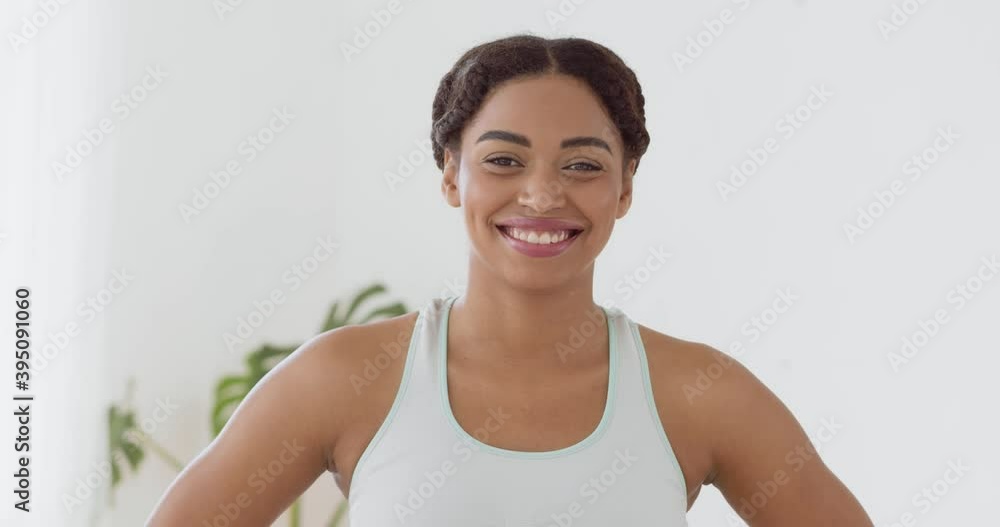 Portrait of cheerful african american lady in sportswear, smiling to camera at home interior Portrait of cheerful african american lady in sportswear, smiling to camera at home interior