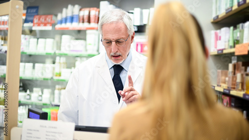 Senior pharmacist dealing with a customer