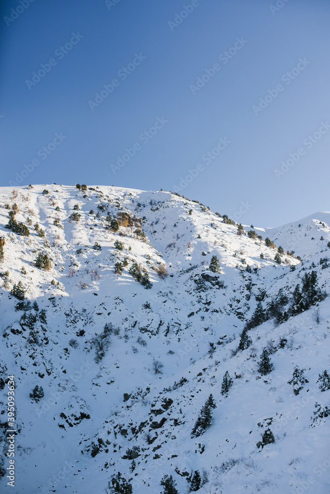Hills covered with snow, in winter on a Sunny day in the mountains of Uzbekistan