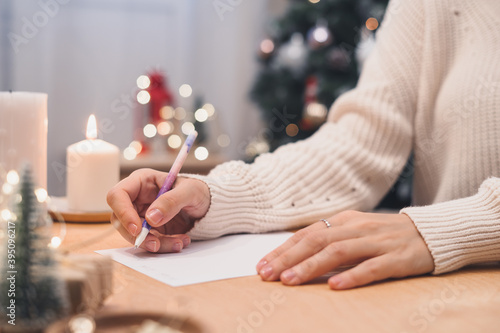 Goals plans make to do and wish list for new year christmas concept writing in notebook. Woman hand holding pen on notepad at home on winter holidays xmas.