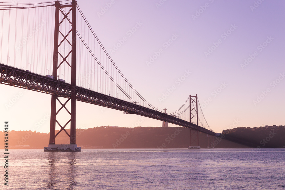Fototapeta premium Ponte 25 de Abril Lisboa Lisbon Portugal bridge and Sanctuary of Christ the King, Santuário de Cristo Rei in the morning sunrise 
