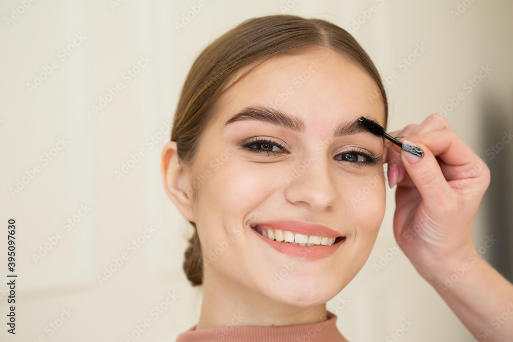 The master combs the eyebrows of a beautiful girl. attractive girl smiling. Well-groomed girl with beautiful thick eyebrows, delicate makeup The master combs the eyebrows of a beautiful girl. attractive girl smiling. Well-groomed girl with beautiful thick eyebrows, delicate makeup