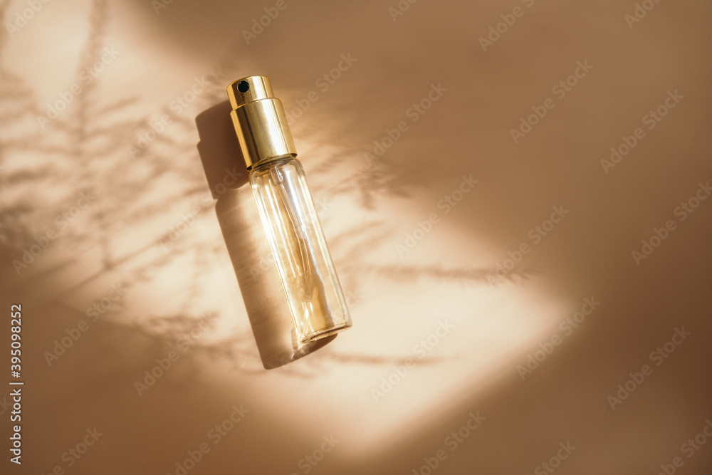 Small perfume golden bottle on warm pastel Small perfume golden bottle on warm pastel