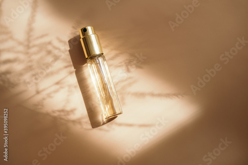 Foto Small perfume golden bottle on warm pastel