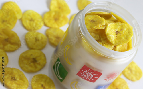 A jar full of dried banana chips a delicacy of South Indian states Healthy sweet snack, crispy dehydrated unsweetened banana chips in colorful glass jar