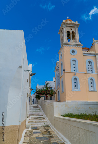 A street with traditional architectrue and St Dimitrios Church in Pyrgos (Panormos) - Tinos Island, Cyclades, Greece photo