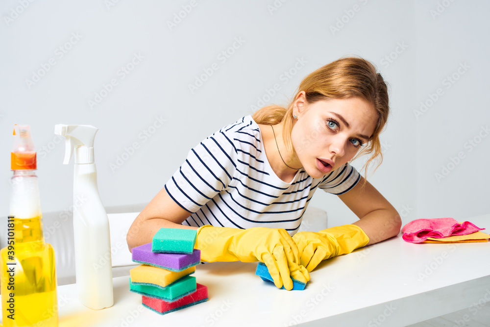 Cheerful cleaning lady wipes the table with detergents cleaning tools Cheerful cleaning lady wipes the table with detergents cleaning tools