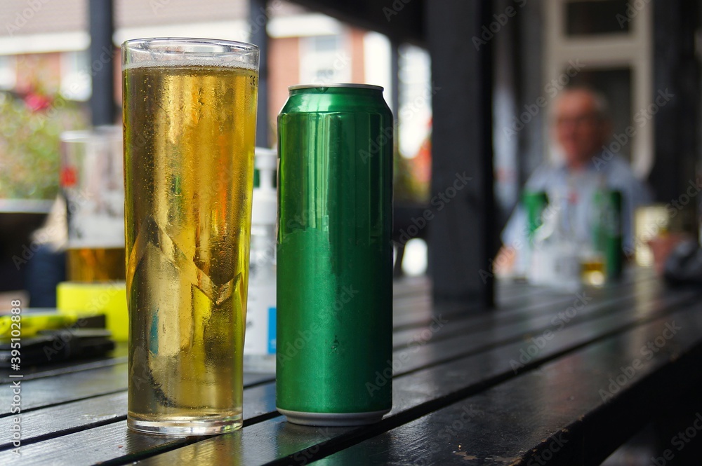 A pint glass of beer and can