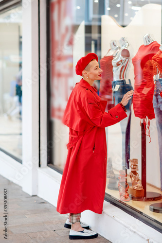 woman in red coat and beret walking around city centre and shopping 