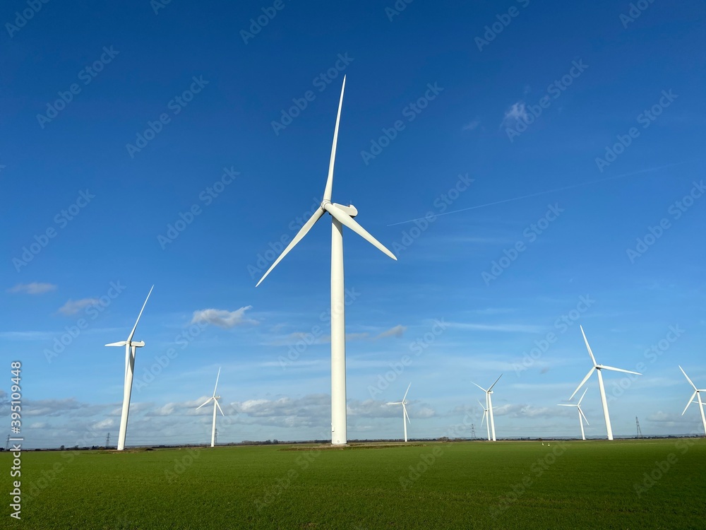 Wind farm turbines that produce electricity energy. Windmill Wind power technology productions Wind turbines standing in green field - stock footage Wind farm turbines that produce electricity energy. Windmill Wind power technology productions Wind turbines standing in green field - stock footage