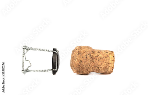 Champagne cork and muselet separately on a white background.