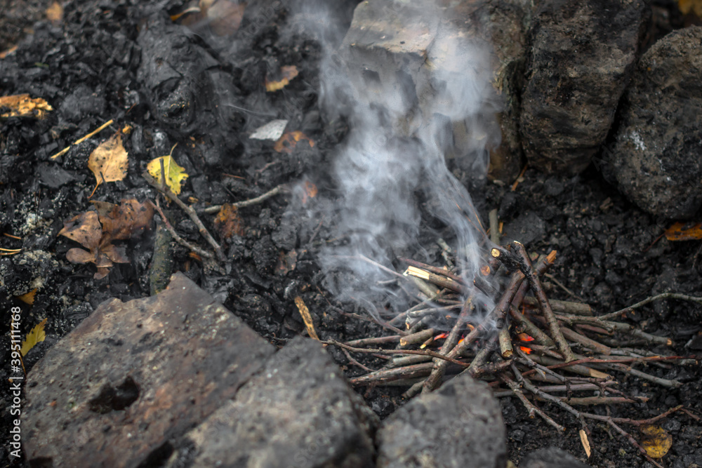 How to make a fire. Burning brushwood. Small branches for a fire. Smoke without fire. How does the fire start? Boy scout skills. Autumn background. How to make a fire. Burning brushwood. Small branches for a fire. Smoke without fire. How does the fire start? Boy scout skills. Autumn background.