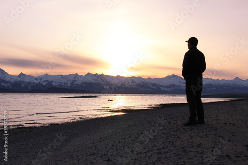 Silhouette of Man on Eagle Beach on Lynn Canal Overlooking the Chilkat Mountain Range in Southeast Alaska