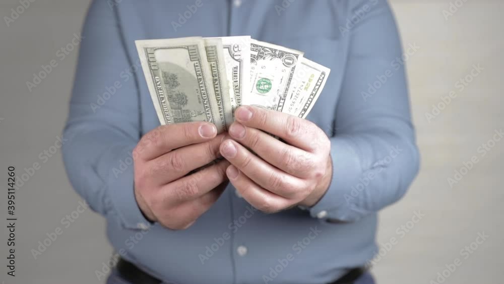 man holding in hands a fan of american dollars close-up man holding in hands a fan of american dollars close-up