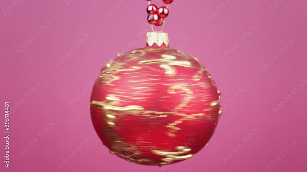 red christmas ball rotating close-up against pink background
red christmas ball rotating close-up against pink background