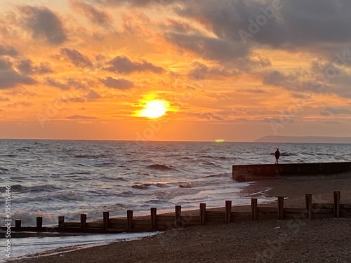 Hastings beach waves and seafront at sunset one man silhouette on concrete pier