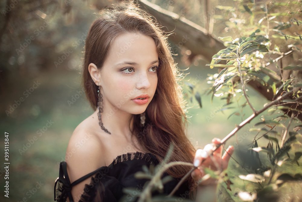 girl stands in the park in autumn in the rays of the setting sun girl stands in the park in autumn in the rays of the setting sun