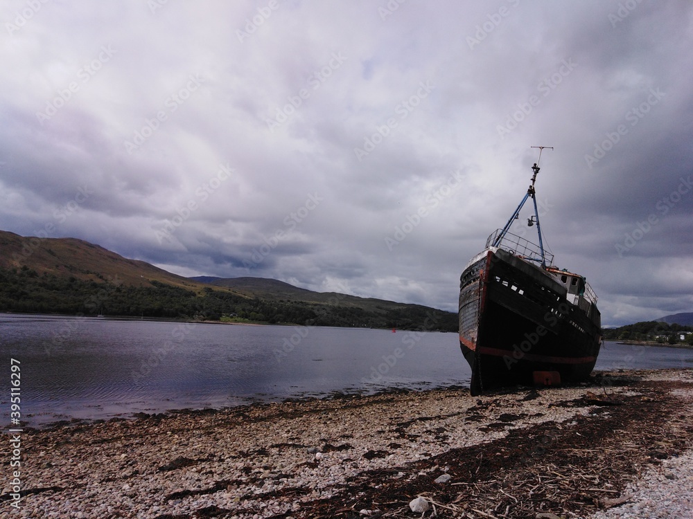 Old fishing boat by the sea with montains background Old fishing boat by the sea with montains background
