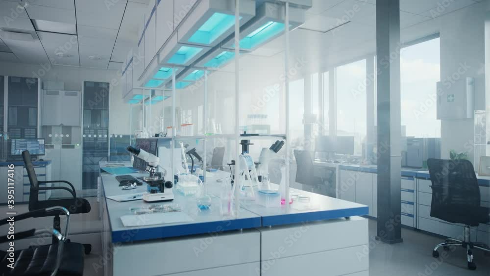 Modern Medical Research Laboratory with Computer, Microscope, Glassware with Biochemicals on the Desk. Scientific Lab Biotechnology Development Center Full of High-Tech Equipment. Moving Shot Modern Medical Research Laboratory with Computer, Microscope, Glassware with Biochemicals on the Desk. Scientific Lab Biotechnology Development Center Full of High-Tech Equipment. Moving Shot